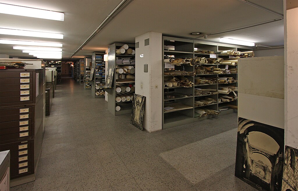 Blick in einen alten Magazinraum mit Regalen, in denen Planrollen liegen